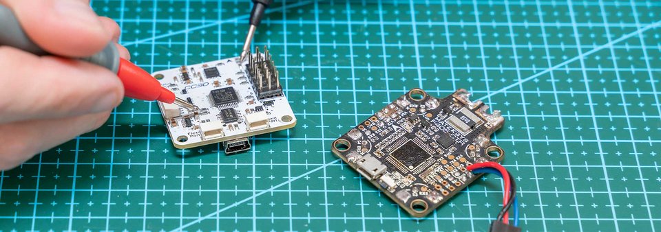 Elektronikentwicklung und Prototypenprüfung bei GLÜCK Industrie-Elektronik mit Messung an einer Leiterplatte im E²MS Umfeld.