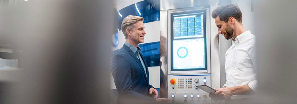 Technische Abstimmung an einer Produktionsanlage bei GLÜCK Industrie-Elektronik im Rahmen der E²MS Elektronikfertigung.